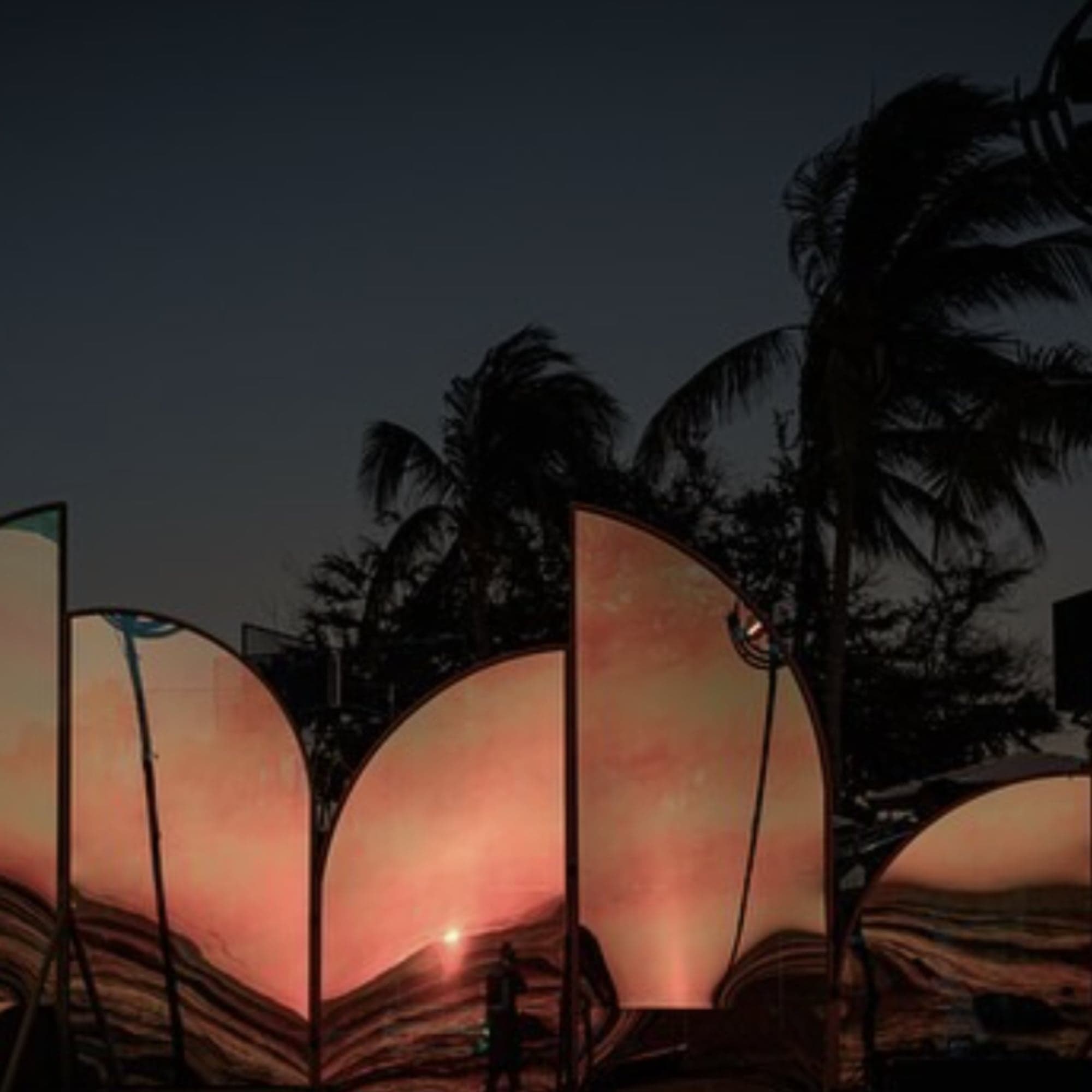 Paneles curvos iluminados al atardecer junto a palmeras, como escenografía para una celebración